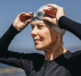 A woman in a wet suit and swim cap, putting her goggles on ready for a triathlon. Swim, Bike, Run, Cramp Dealing with Leg Cramps in Triathlons