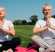 Two people in a park doing a yoga pose and practising mind and body techniques for managing leg cramps